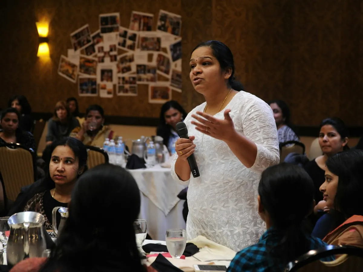 A woman speaking to a room of women at a Women in AI gathering